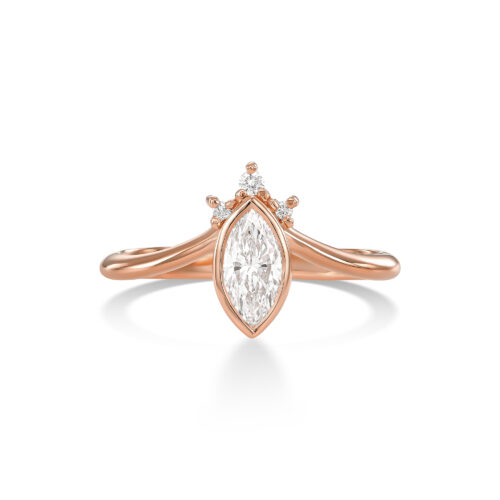 טבעת עם יהלום מרקיזה מרכזי, משובץ במסגרת זהב עדינה שעוקבת אחרי קווי האבן בצורה מדויקת, כמעט הדוקה — לא רק כאחיזה, אלא כהדגשה של הצורה עצמה. המרקיזה הוא חיתוך מאוד מובחן, עם ציר אורכי חזק וקצוות חדים, ולכן כל שאר האלמנטים בטבעת נבנו מתוך התייחסות אליו — לא להתחרות בו, אלא להוביל אליו. מעל האבן שילבתי שיבוץ של יהלומים קטנים במבנה שמזכיר כתר, אבל לא ככתר סימטרי או “קלאסי”, אלא כזה שיש בו משחק — שינויים קטנים בגובה, במרווחים, ובכיוון השיבוץ, שיוצרים תנועה עדינה וניצוץ לא אחיד. זה אלמנט שמרגיש כמעט מרחף מעל האבן, ומוסיף לה שכבה נוספת של אור. המסגרת שסוגרת את המרקיזה בוחרת לא ללכת על שיניים, אלא על קו זהב רציף שמדגיש את הצורה השלמה של החיתוך, ונותן תחושה יותר נקייה, יותר גרפית, ופחות מפורקת. הטבעת עצמה מתפצלת משני הצדדים לקווים כפולים, שנפתחים החוצה מהמרכז בתנועה רכה יותר. הפיצול הזה יוצר איזון מול החדות של האבן — מצד אחד יש ציר מאוד ברור ומוגדר, ומצד שני קווים שמתנהגים כמעט כמו זרימה. מה שעניין אותי בעיצוב הזה הוא היחס בין מבנה לתנועה — בין אלמנט מאוד מדויק ומאורגן, לבין חלקים שמרגישים חופשיים יותר. המרקיזה כאן הוא לא רק אבן מרכזית, אלא נקודת מוצא שממנה כל הטבעת נבנית ומתפתחת. זו טבעת שהיופי שלה לא רק בפרטים עצמם, אלא באופן שבו הם מחזיקים יחד.