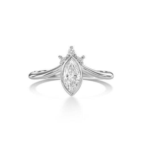 טבעת עם יהלום מרקיזה מרכזי, משובץ במסגרת זהב עדינה שעוקבת אחרי קווי האבן בצורה מדויקת, כמעט הדוקה — לא רק כאחיזה, אלא כהדגשה של הצורה עצמה. המרקיזה הוא חיתוך מאוד מובחן, עם ציר אורכי חזק וקצוות חדים, ולכן כל שאר האלמנטים בטבעת נבנו מתוך התייחסות אליו — לא להתחרות בו, אלא להוביל אליו. מעל האבן שילבתי שיבוץ של יהלומים קטנים במבנה שמזכיר כתר, אבל לא ככתר סימטרי או “קלאסי”, אלא כזה שיש בו משחק — שינויים קטנים בגובה, במרווחים, ובכיוון השיבוץ, שיוצרים תנועה עדינה וניצוץ לא אחיד. זה אלמנט שמרגיש כמעט מרחף מעל האבן, ומוסיף לה שכבה נוספת של אור. המסגרת שסוגרת את המרקיזה בוחרת לא ללכת על שיניים, אלא על קו זהב רציף שמדגיש את הצורה השלמה של החיתוך, ונותן תחושה יותר נקייה, יותר גרפית, ופחות מפורקת. הטבעת עצמה מתפצלת משני הצדדים לקווים כפולים, שנפתחים החוצה מהמרכז בתנועה רכה יותר. הפיצול הזה יוצר איזון מול החדות של האבן — מצד אחד יש ציר מאוד ברור ומוגדר, ומצד שני קווים שמתנהגים כמעט כמו זרימה. מה שעניין אותי בעיצוב הזה הוא היחס בין מבנה לתנועה — בין אלמנט מאוד מדויק ומאורגן, לבין חלקים שמרגישים חופשיים יותר. המרקיזה כאן הוא לא רק אבן מרכזית, אלא נקודת מוצא שממנה כל הטבעת נבנית ומתפתחת. זו טבעת שהיופי שלה לא רק בפרטים עצמם, אלא באופן שבו הם מחזיקים יחד.